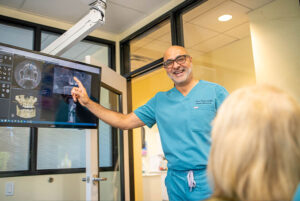 doctor pointing at an xray on a computer screen in a dental office